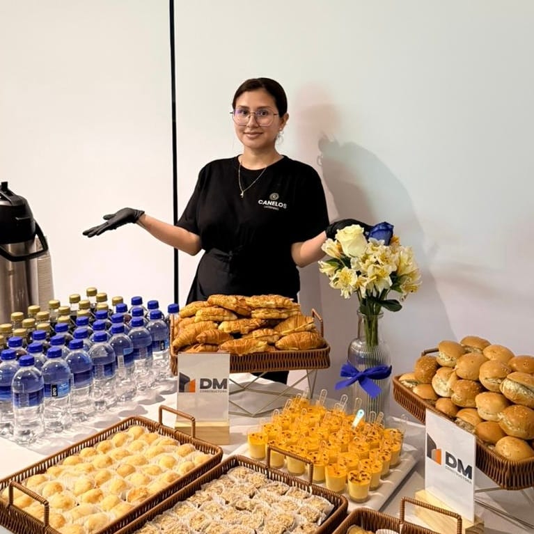Colaboradora de Catering Canelos atendiendo una mesa de bocaditos